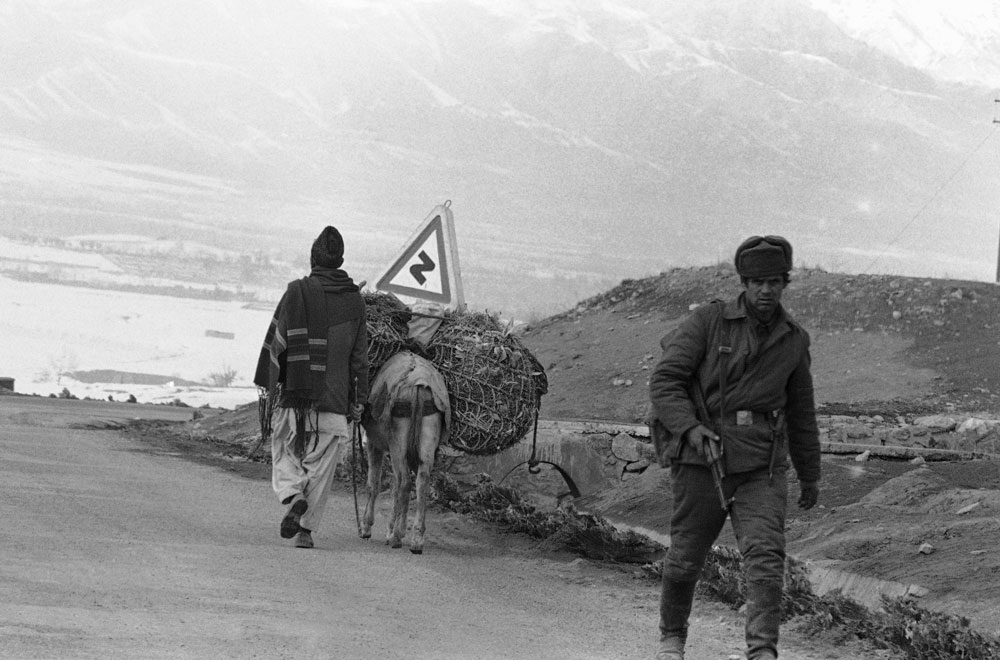 Советский солдат проходит мимо местного жителя в горах неподалеку от Кабула, 1980 год