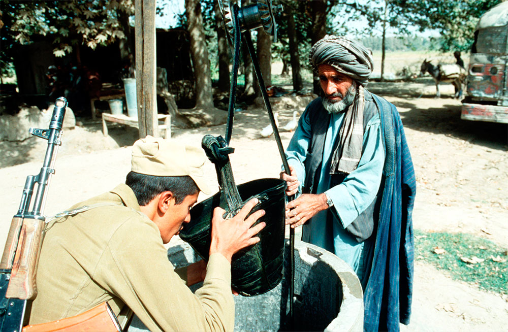 Советский солдат пьет воду из ведра местного жителя, 1986 год